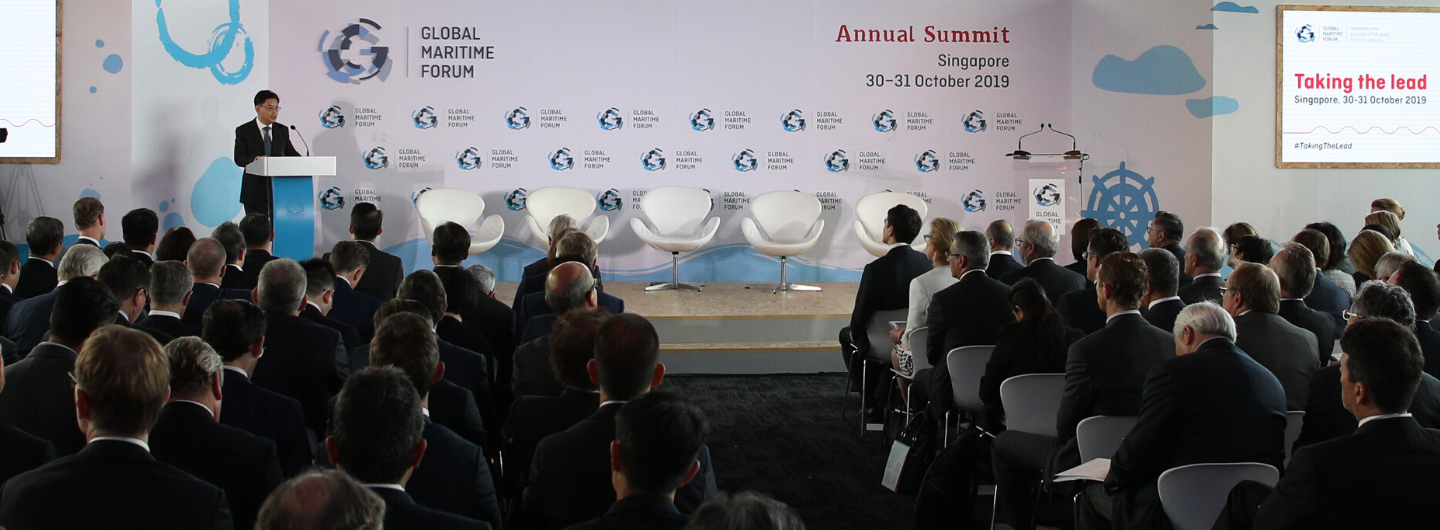 Speaker at podium addresses audience at Global Maritime Forum Annual Summit.
